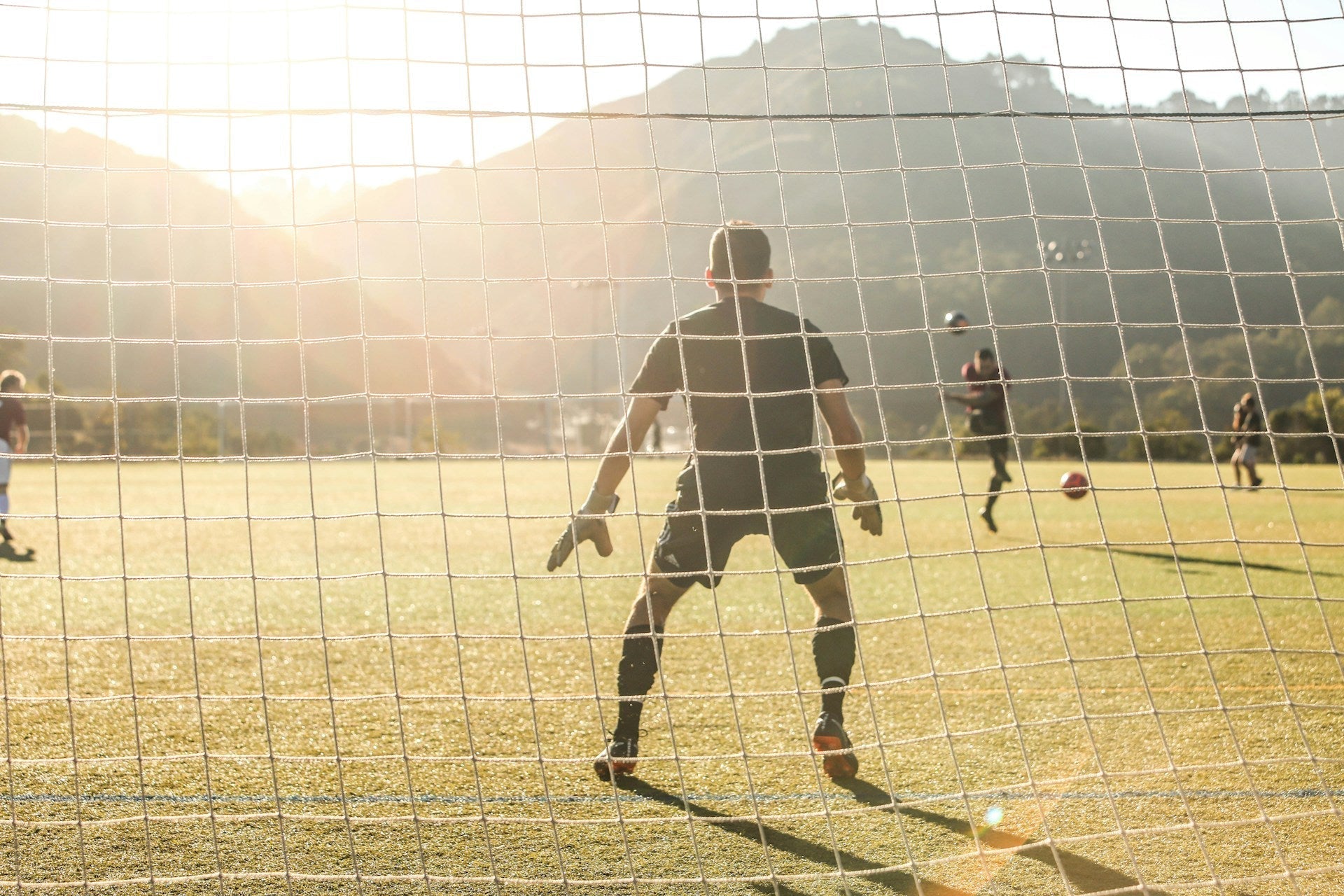 Soccer goalkeeper in position behind the net waiting for a shot